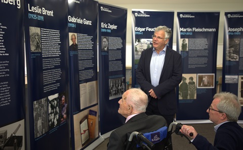 Three men looking at a selection of pull-up banners. 