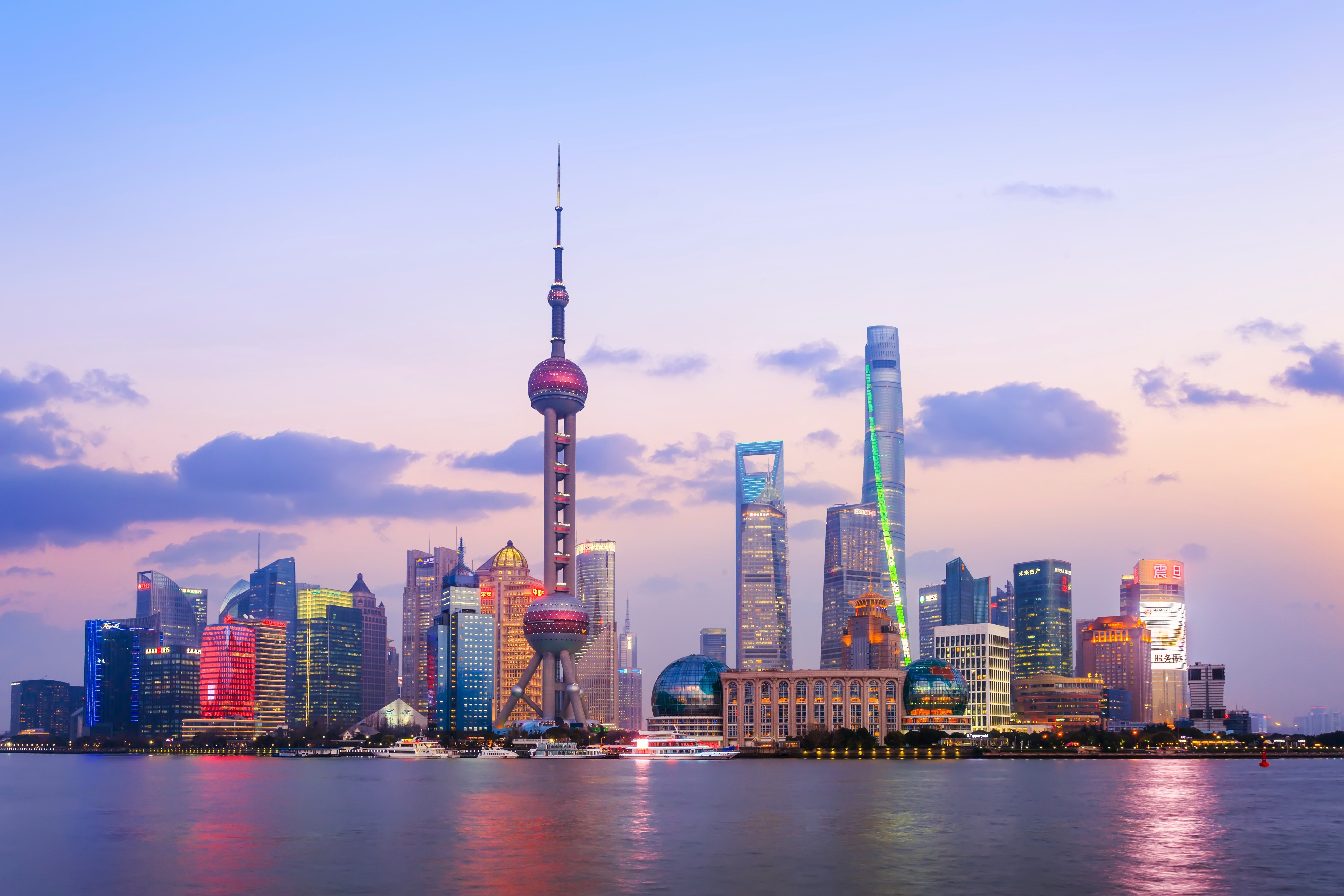 A panoramic evening view of Shanghai’s modern skyline seen across the Huangpu River. The Oriental Pearl Tower, with its distinctive pink spheres, stands prominently in the centre. Surrounding it are illuminated skyscrapers, including the Shanghai World Financial Center and the twisting Shanghai Tower. The sky is softly lit with pastel shades of blue and pink as city lights reflect on the water in the foreground.Do you like this personality?