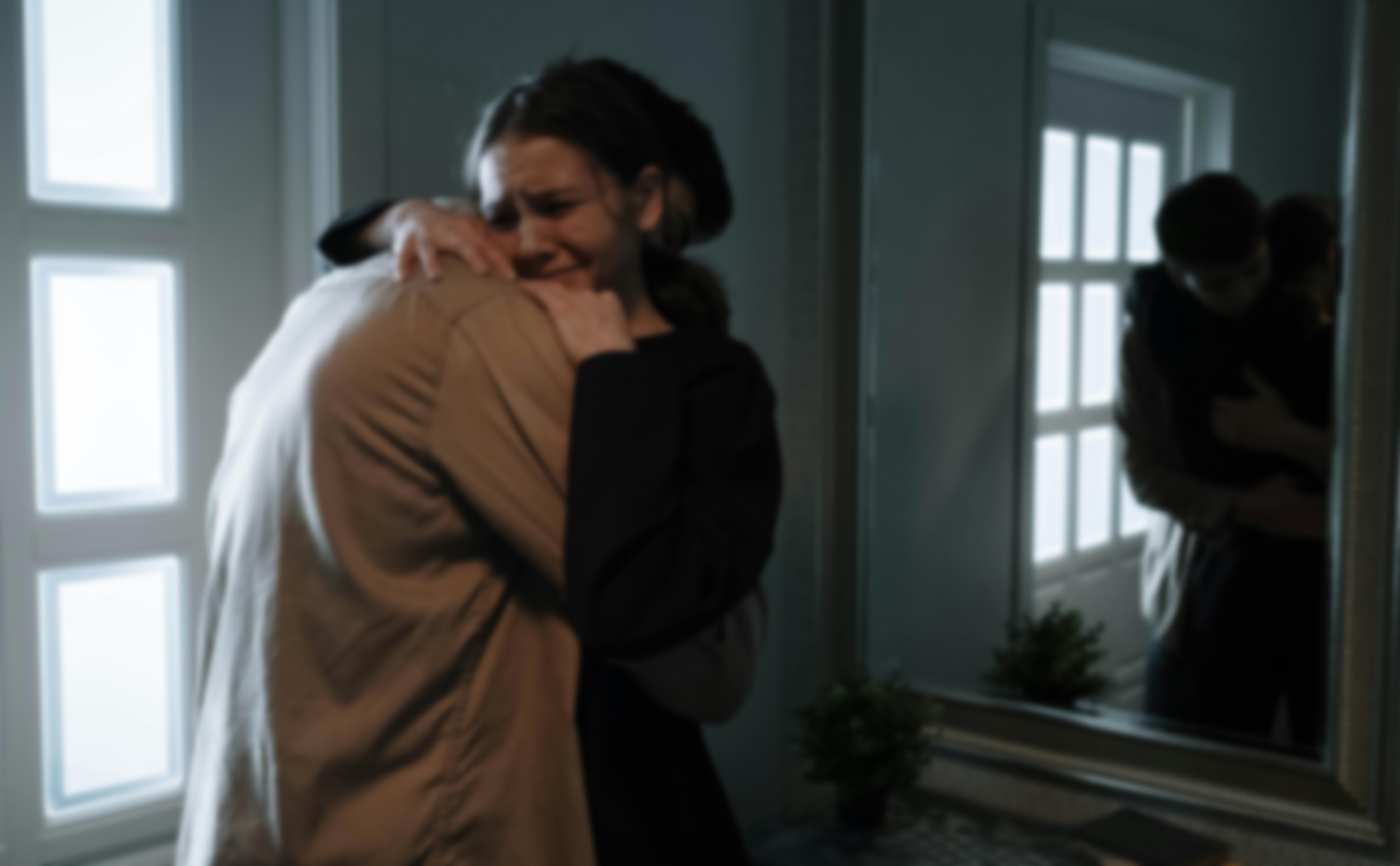 Blurred image of a young man and woman hugging each other in emotional support