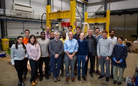 A group of people are all standing together, facing the same way