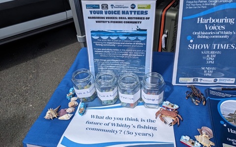 Table with survey jars and signs about Whitby’s fishing community.