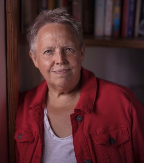 Harriet Wistrich leaningagainst a door post looking at the camera