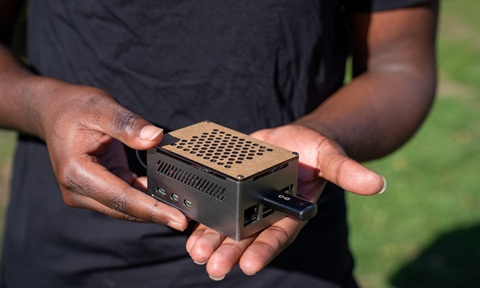 Close up of a palm-sized electronic box in someone's hand