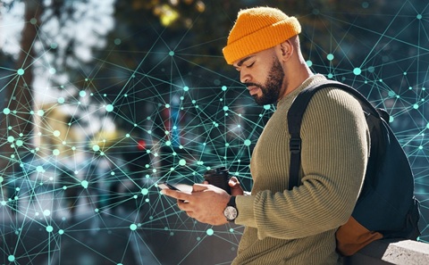 Person outdoors using a smartphone, with digital network lines overlayed in the background.