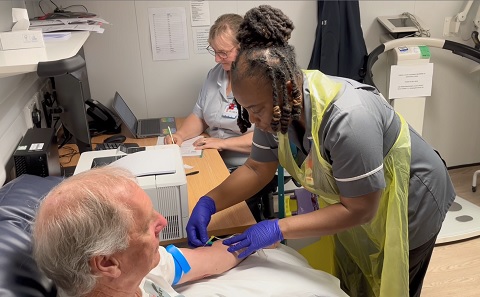 A research nurse taking a blood sample from a trial patient