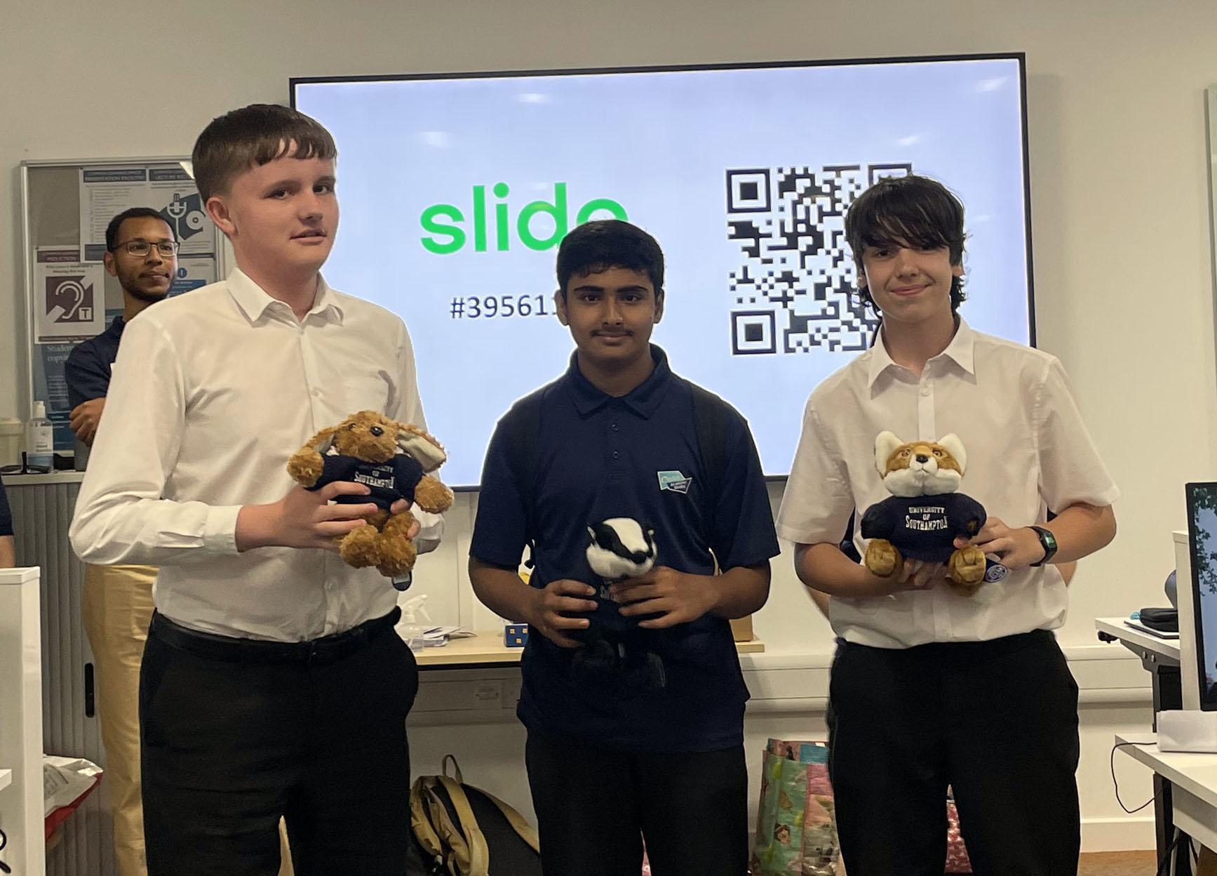 The three winners of the quiz, holding their university mascot cuddly toys 