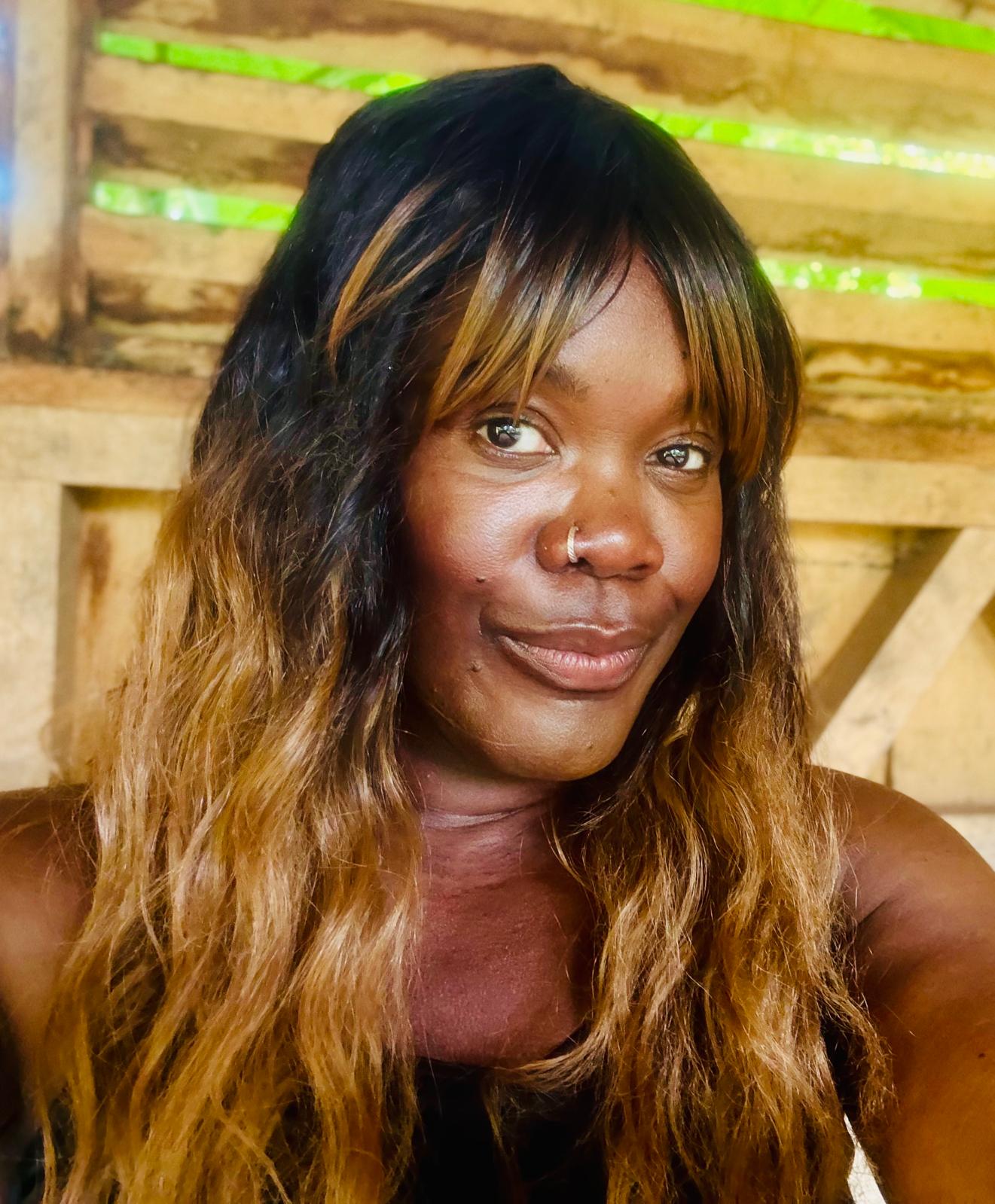 Ophelia Watson looking at the camera with a wood structure in the background.