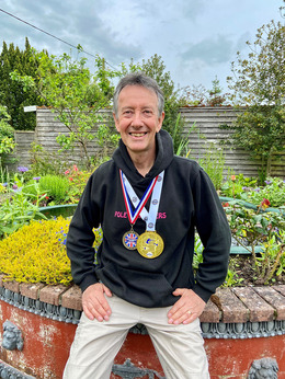 Paul Bradley with his British and World Champion pole sport medals. 