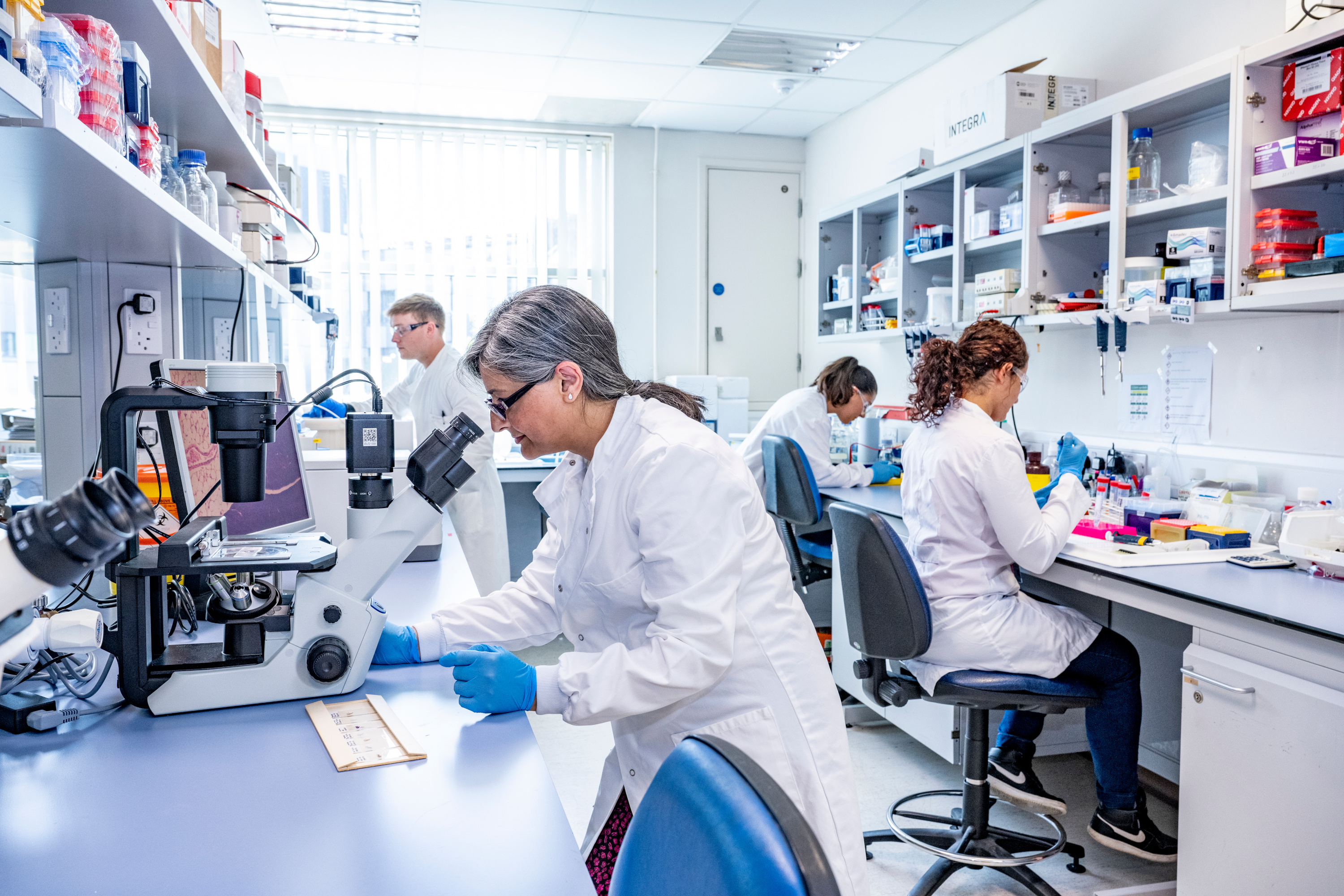 Prof Jaswinder Sethi looking into microscope in University of Southampton labs