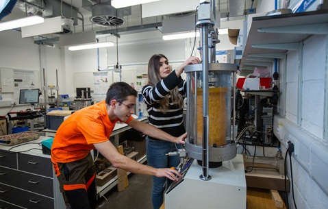 PhD students Rafael Periera-Anjos and Saba Ghassemi performing cyclical triaxial testing of scaled railway ballast with novel geosynthetic reinforcements 
