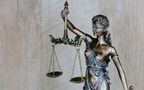 Bronze statue of a woman wearing a blindfold, holding up the scales of justice