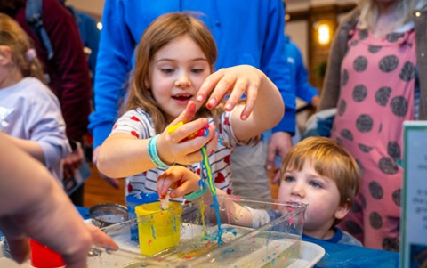 Young girl playing with red and green slime