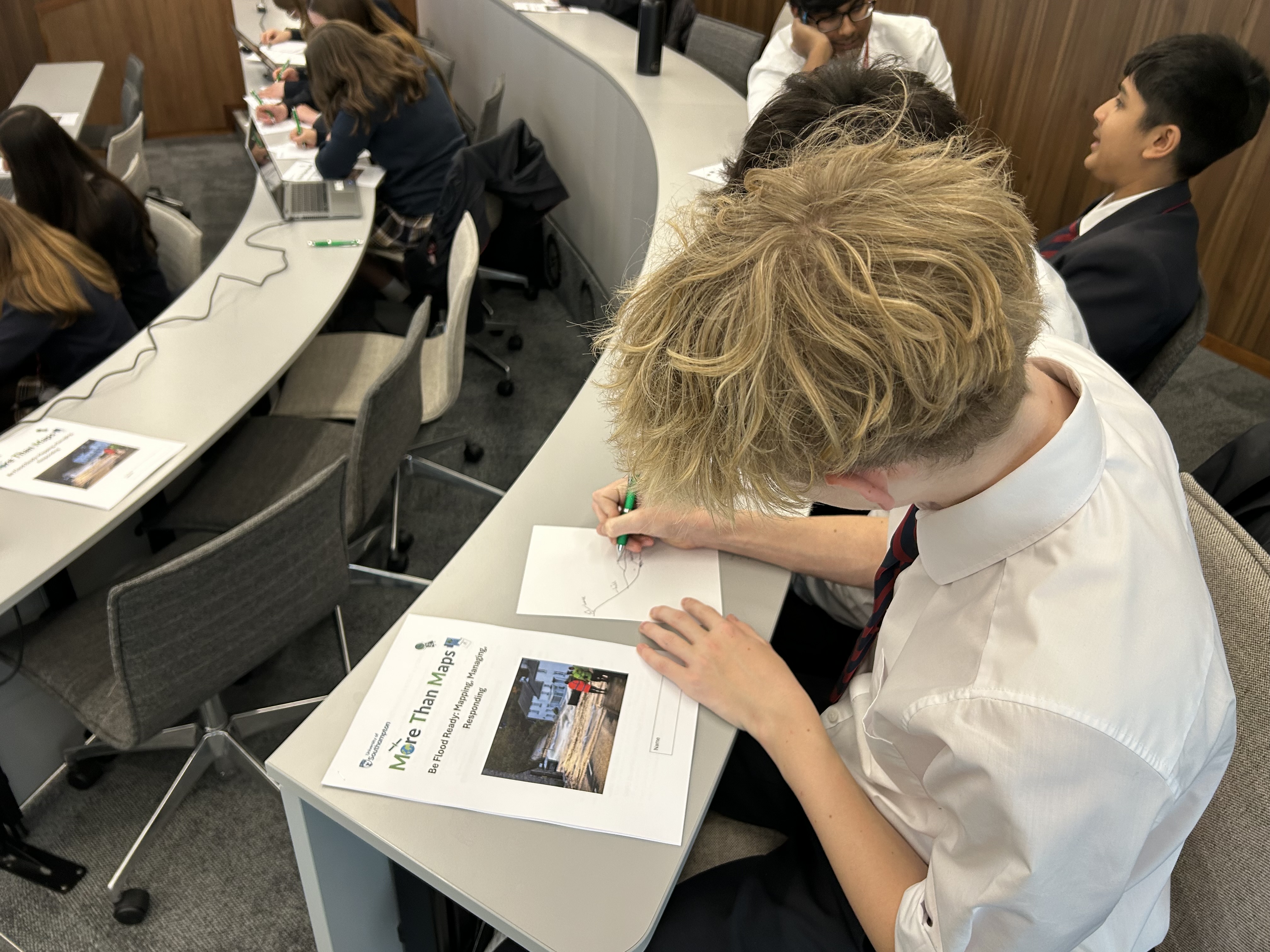 Students working at crescent desks in a classroom.