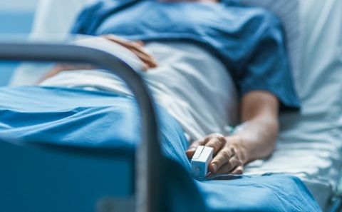 A close-up of a surgical patient lying in a hospital bed