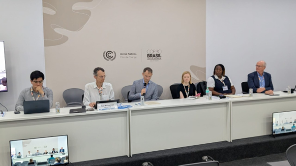 UNFCCC officials sitting behind a long desk as they talk to the audience.