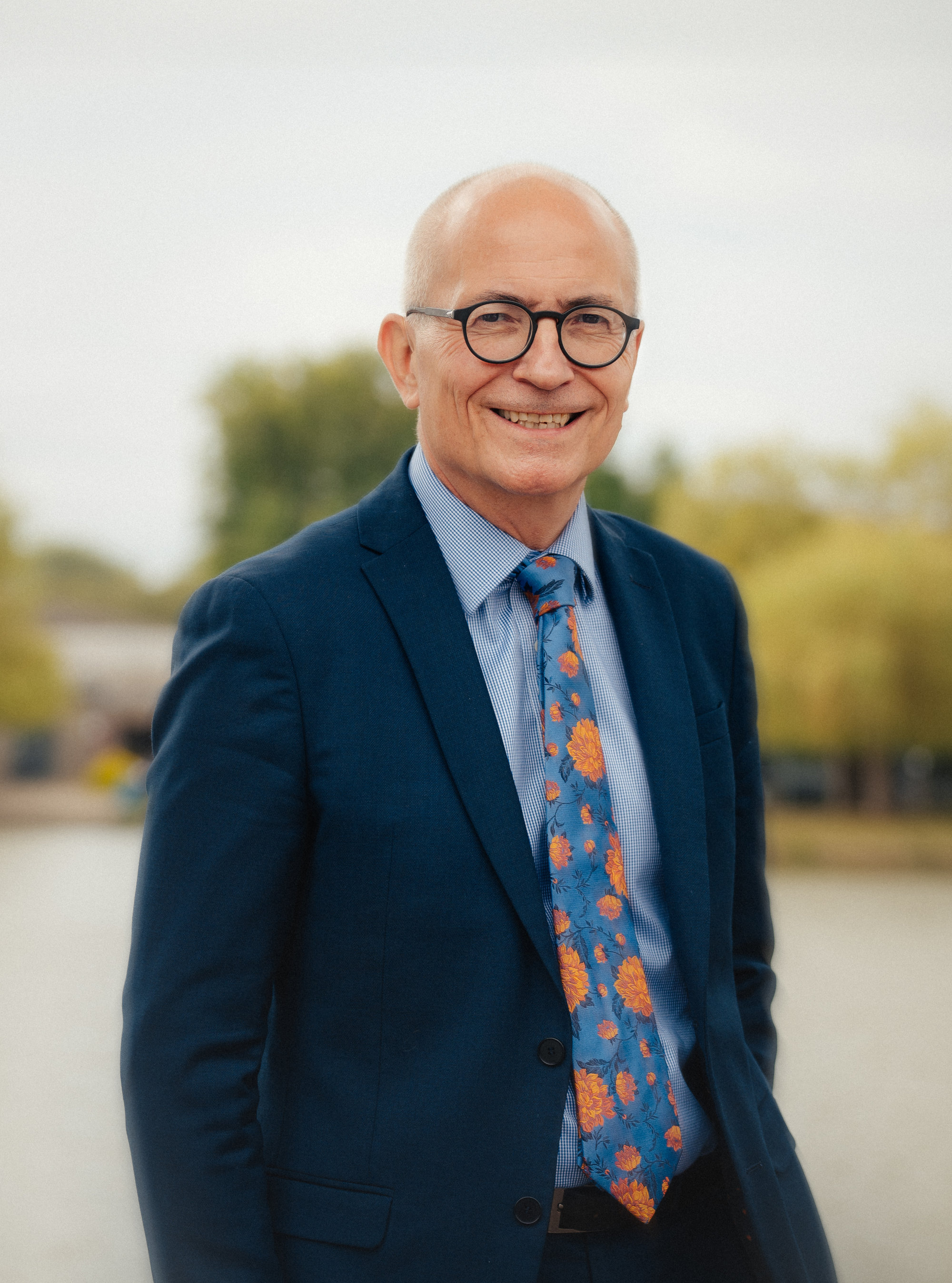 Professor Charlie Jeffery CBE smiling into the camera in black suit