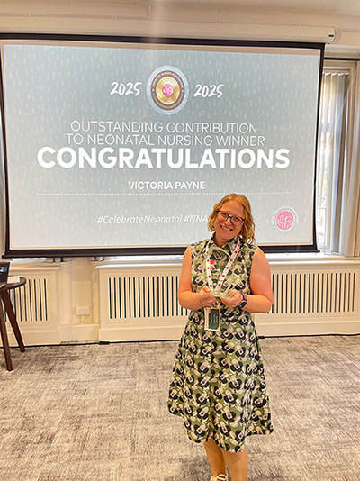 Vicky Payne with award smiling at camera.