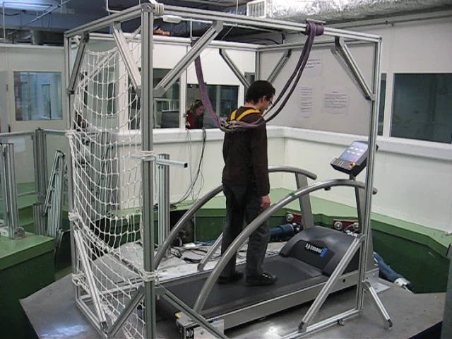 Participant walking on an instrumented treadmill within a safety harness system used for gait and balance research