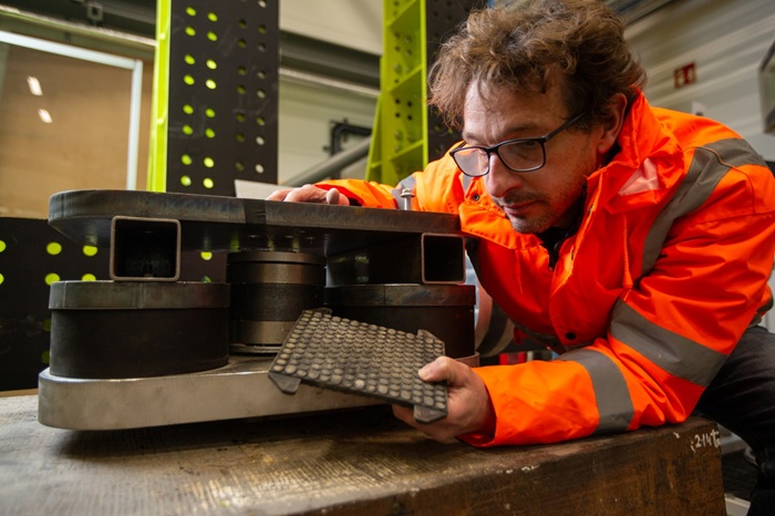 Researcher inspecting a vibration testing rig in a laboratory environment