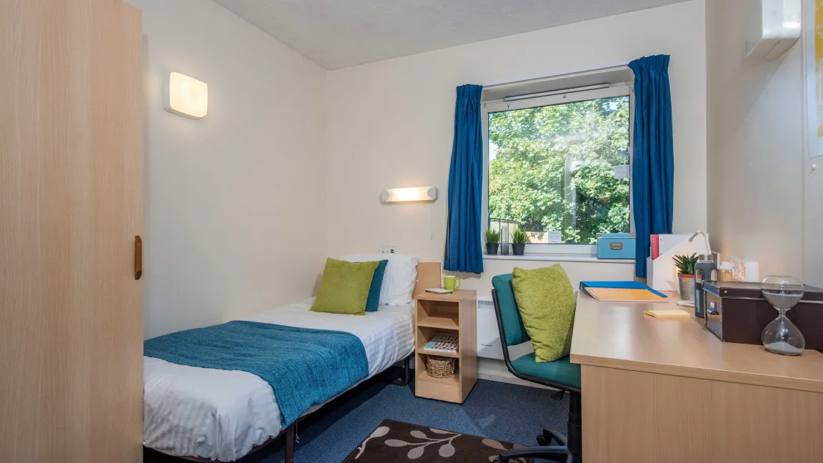 Student bedroom showing bed and desk.