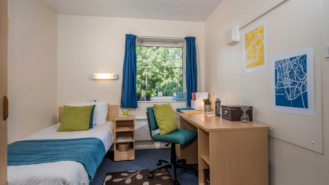 Student bedroom showing bed and desk.