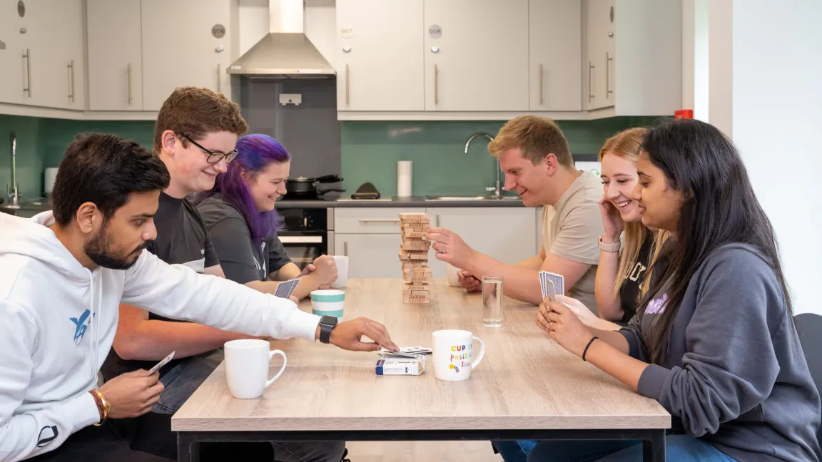 Students in accommodation at a dining table.