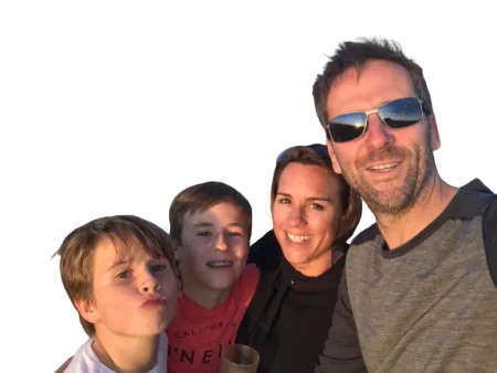 Clinical Trial participant Crispin smiling in sunlight with his wife and two sons