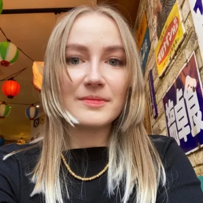 A female with long blonde hair looks directly at the camera