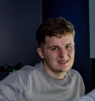 Head and shoulders portrait image of Freddie Barnes-Janes, BA Film and English student smiling at the camera.