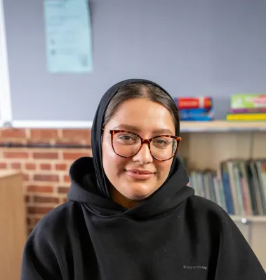 Head and shoulders portrait image of Madihah Ali smiling at the camera.