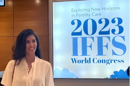 Hannah at the IFFS congress in Athens standing in front of the sign