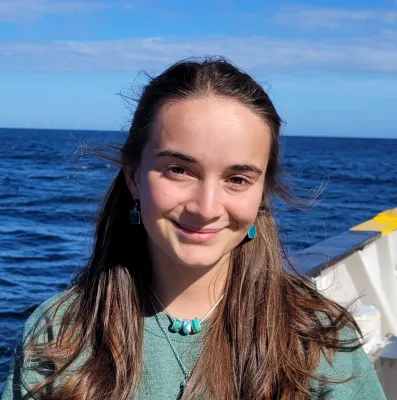 A portrait image of Sara on the research vessel, smiling at the camera