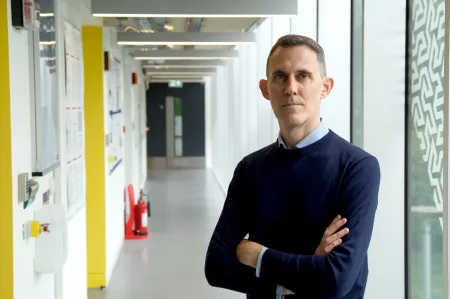 Dr Giorgio Adamo standing a a corridor looking at the camera.