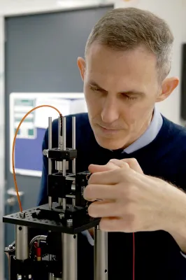 A close up shot of Dr Giorgio Adamo adjusting a piece of equipment.