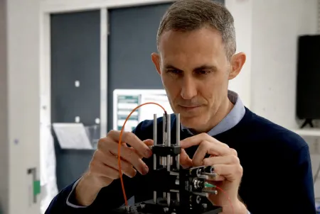 Dr Giorgio Adamo adjusting electronic equipment.