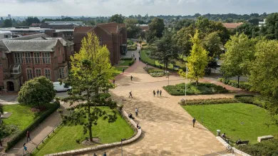 Aerial view of campus buildings, trees and courtyard area on a sunny day.