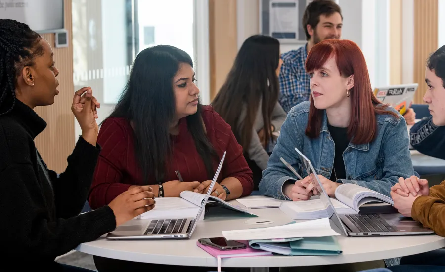 four undergraduate accelerated law students discussing round a table