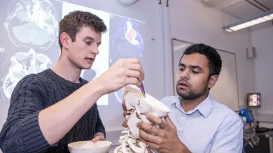 Two students look inside a human skull in the clinical skills suite