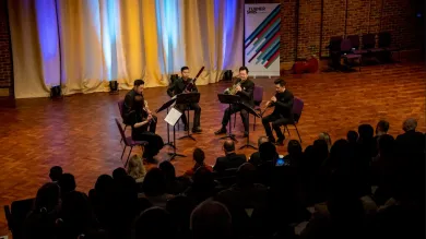 A group of five musicians perform on stage at Turner Sims concert hall