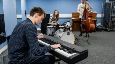 A group of three students practising in a music ensemble room