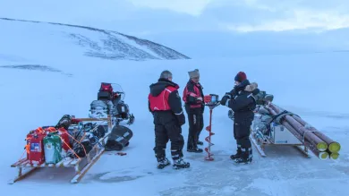 A team of scientists with equipment carrying out field research on a glacier