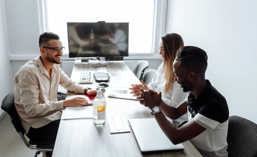 three people in discussion in business meeting room