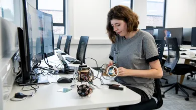A researcher at a desk with computers and electronic equipment