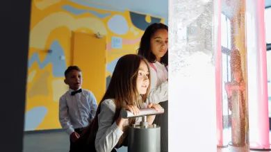 Children looking at coloured liquids in large tubes