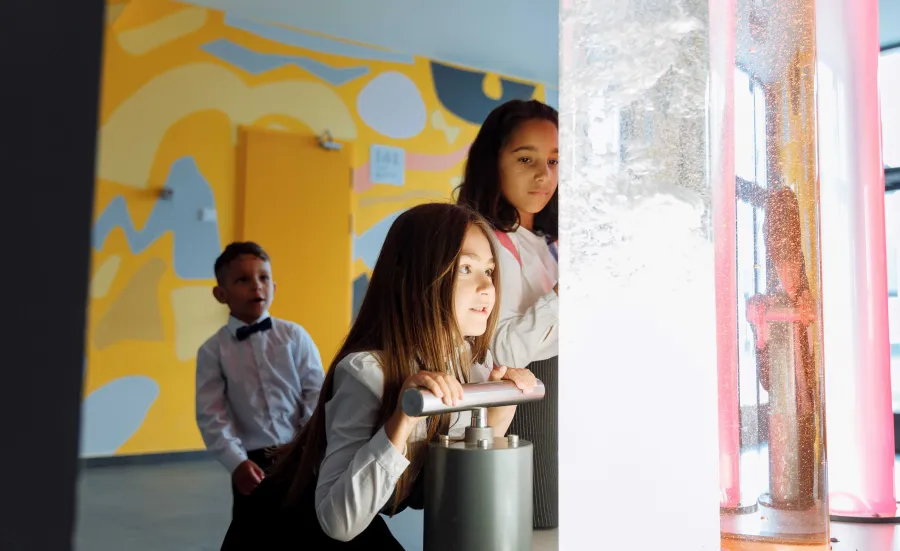 Children looking at coloured liquids in large tubes