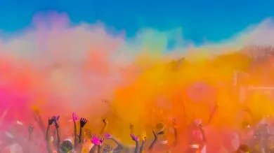 Group of people throwing coloured powder in the air