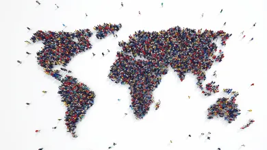 A crowd of people photographed from above, making up a map of the world