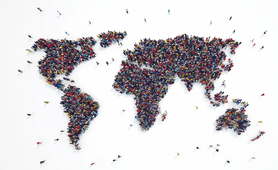 A crowd of people photographed from above, making up a map of the world