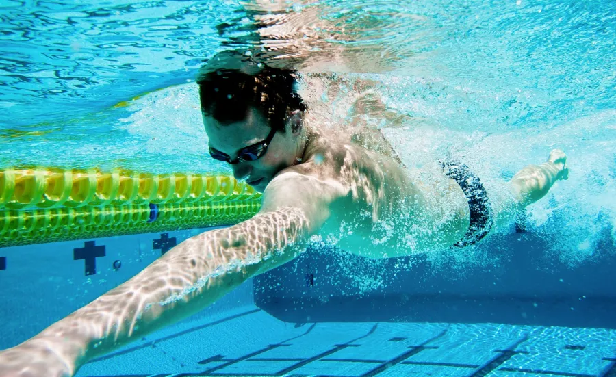 Man swimming under water in a swimming pool.