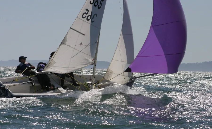 Two sailors in a small boat in rough waters